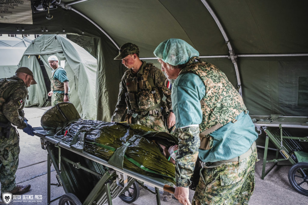 De chirurgen helpen met het vervoer van de patienten binnen de Role 2 Enhanced